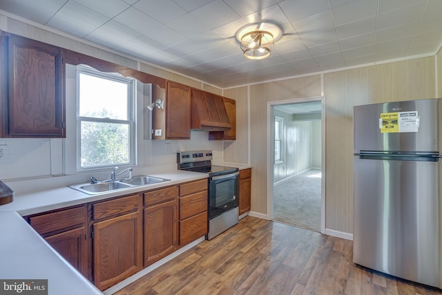 kitchen featuring appliances with stainless steel finishes, custom exhaust hood, light countertops, and a sink