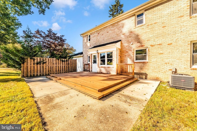 rear view of property featuring a wooden deck, cooling unit, and a lawn