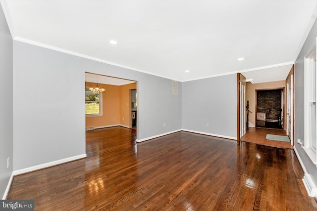 unfurnished living room with ornamental molding, a chandelier, and dark wood-type flooring