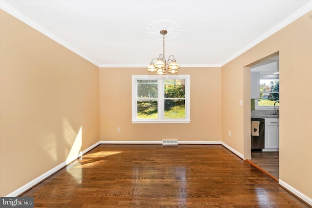 unfurnished dining area with crown molding, dark hardwood / wood-style floors, a chandelier, and sink