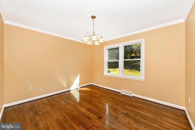 empty room with a notable chandelier, hardwood / wood-style flooring, and crown molding