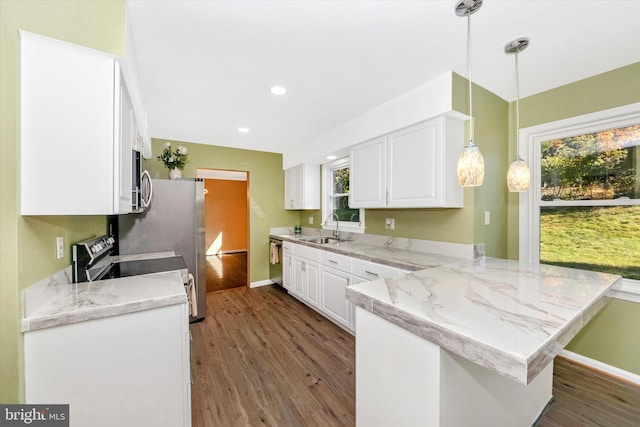 kitchen featuring hanging light fixtures, white cabinetry, and kitchen peninsula