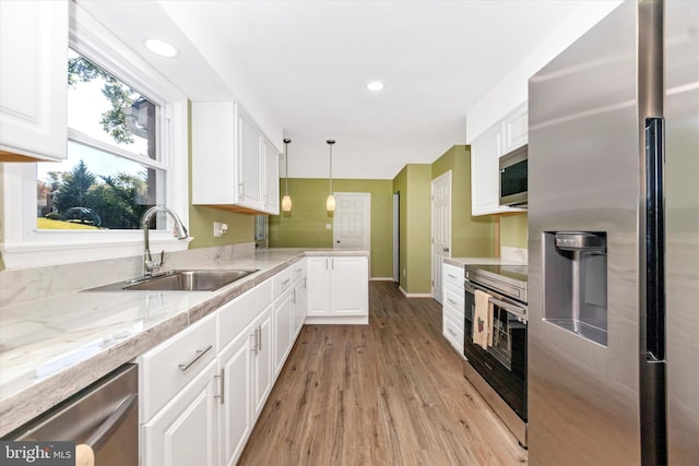 kitchen with light hardwood / wood-style floors, white cabinets, stainless steel appliances, and sink