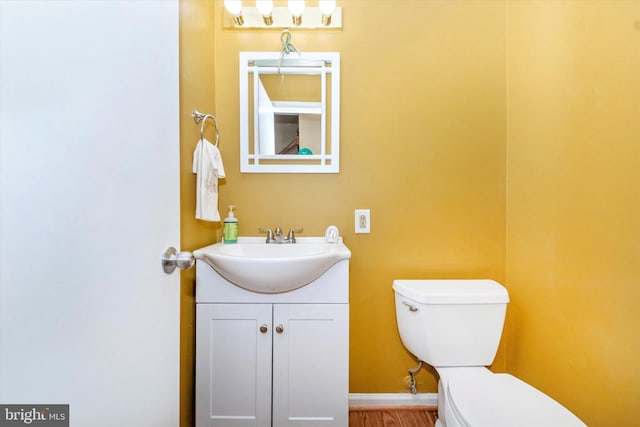 bathroom featuring toilet, vanity, and wood-type flooring