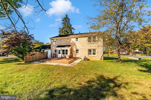 rear view of house with a patio, cooling unit, and a lawn