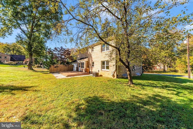 rear view of property with a wooden deck, cooling unit, and a yard