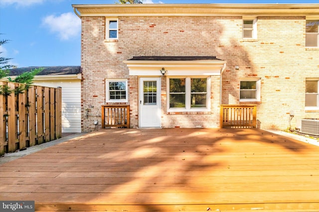 rear view of property featuring cooling unit and a deck