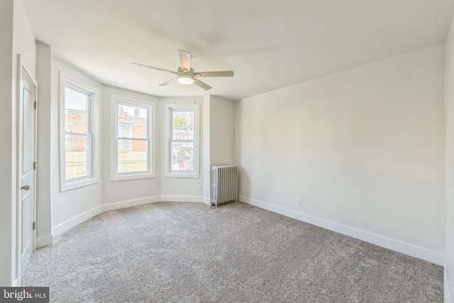 unfurnished room featuring radiator, light carpet, and ceiling fan