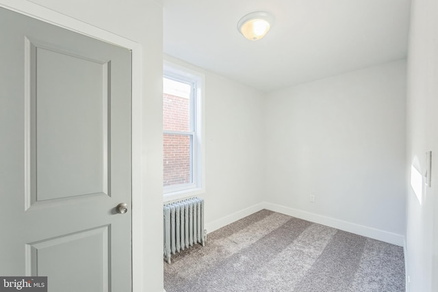 carpeted spare room featuring radiator heating unit