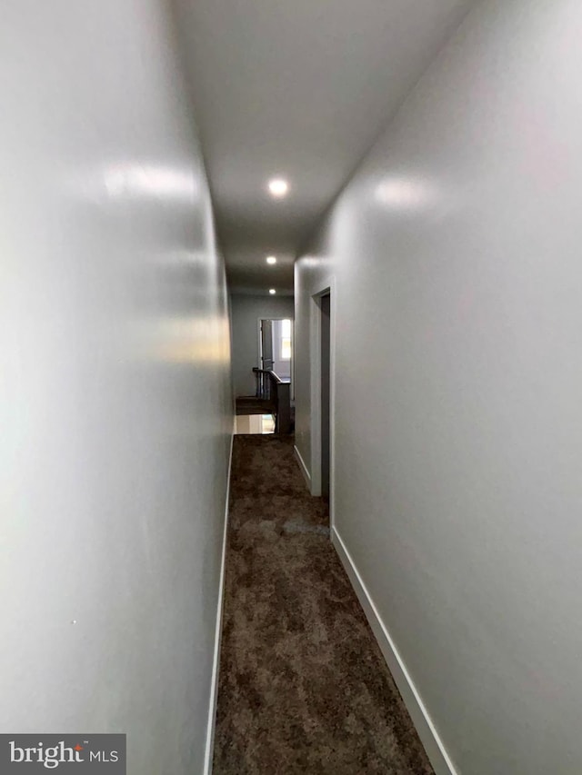 hallway with dark colored carpet