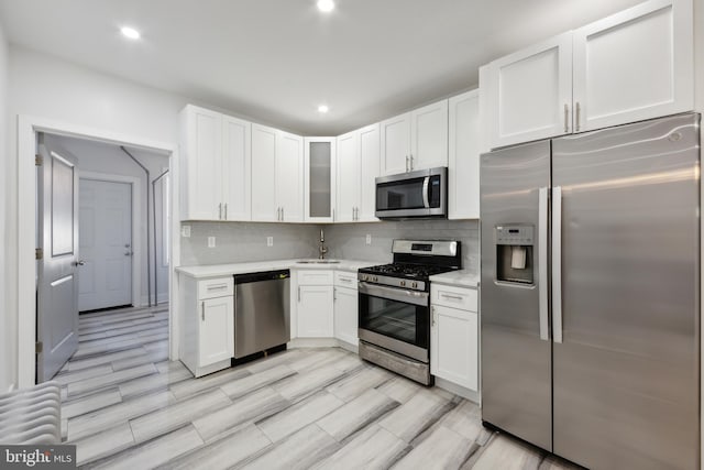 kitchen featuring tasteful backsplash, white cabinetry, and appliances with stainless steel finishes