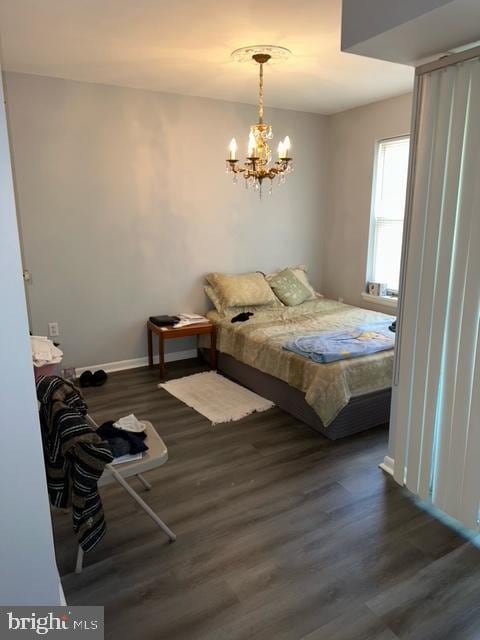 bedroom featuring a chandelier and dark hardwood / wood-style flooring