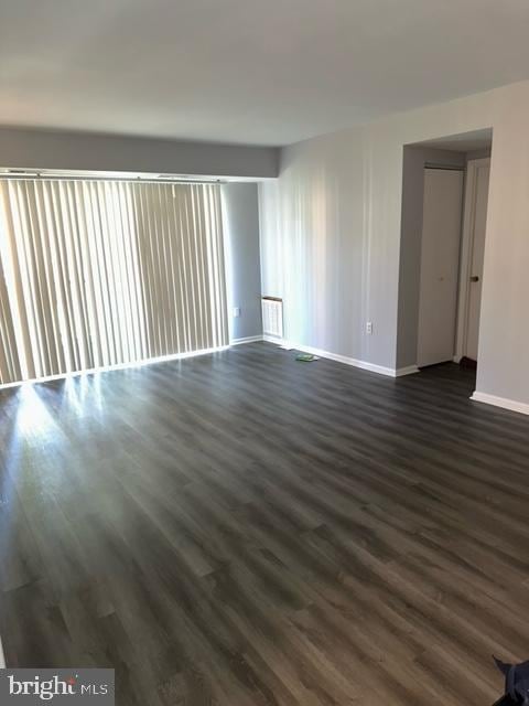 empty room with dark hardwood / wood-style flooring