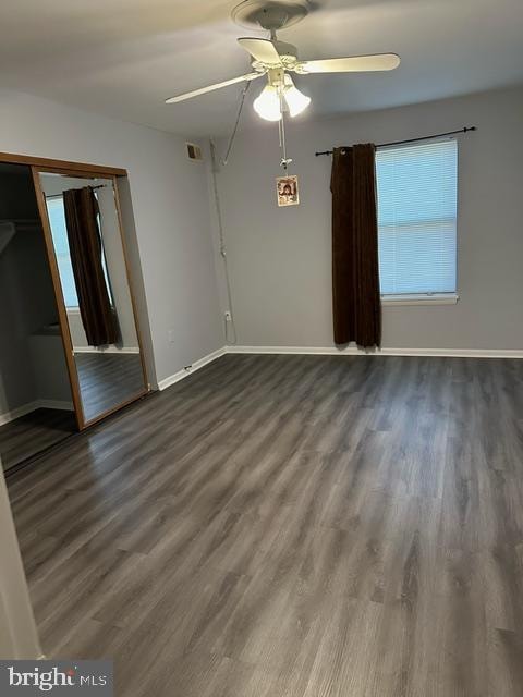 empty room with ceiling fan and dark hardwood / wood-style floors