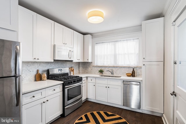 kitchen with decorative backsplash, sink, white cabinets, and appliances with stainless steel finishes