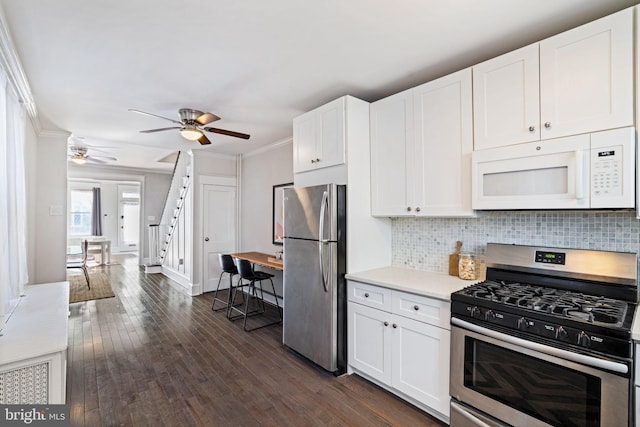 kitchen with white cabinets, decorative backsplash, stainless steel appliances, and crown molding