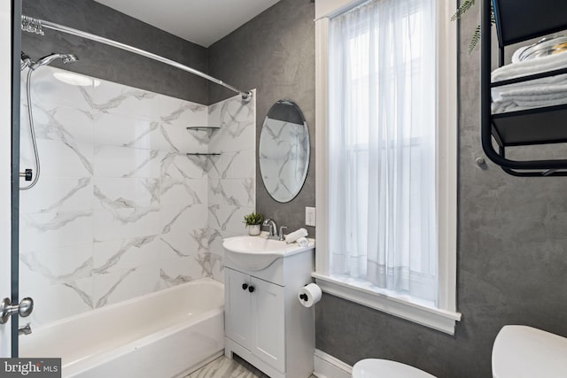 full bathroom featuring tiled shower / bath combo, toilet, and vanity