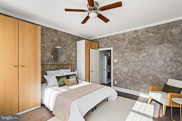 bedroom featuring dark hardwood / wood-style flooring, stacked washing maching and dryer, ceiling fan, and ornamental molding