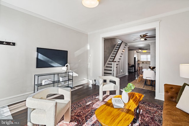 living room featuring dark hardwood / wood-style flooring, ceiling fan, and crown molding