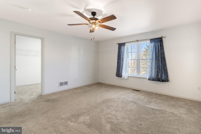 empty room featuring carpet, visible vents, and baseboards