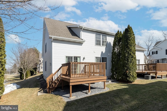 back of property with central AC, roof with shingles, a yard, and a deck