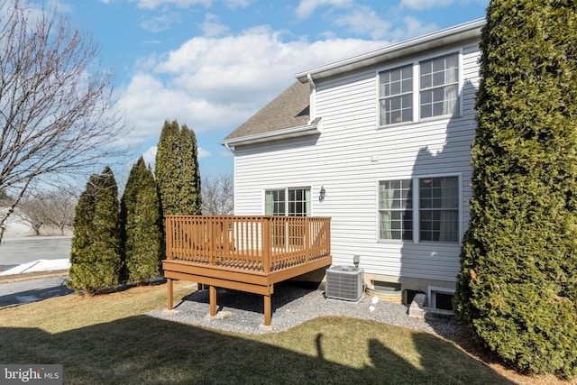 rear view of house featuring a deck, a yard, roof with shingles, and cooling unit