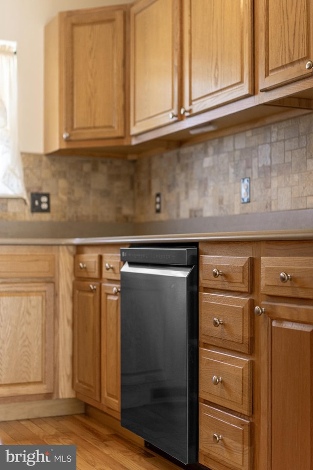 kitchen with dishwasher, light countertops, tasteful backsplash, and light wood-style floors