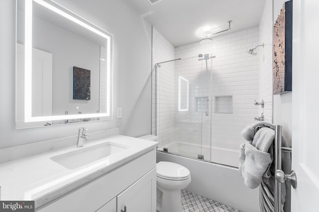 full bathroom featuring vanity, toilet, combined bath / shower with glass door, and tile patterned flooring