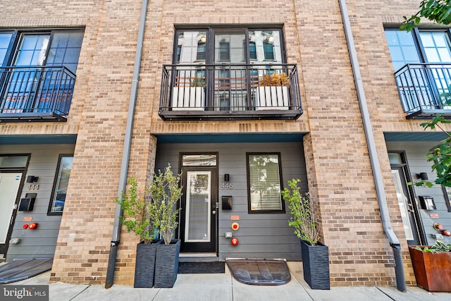 view of exterior entry with a balcony