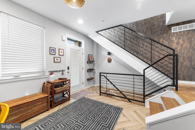 stairway featuring parquet floors