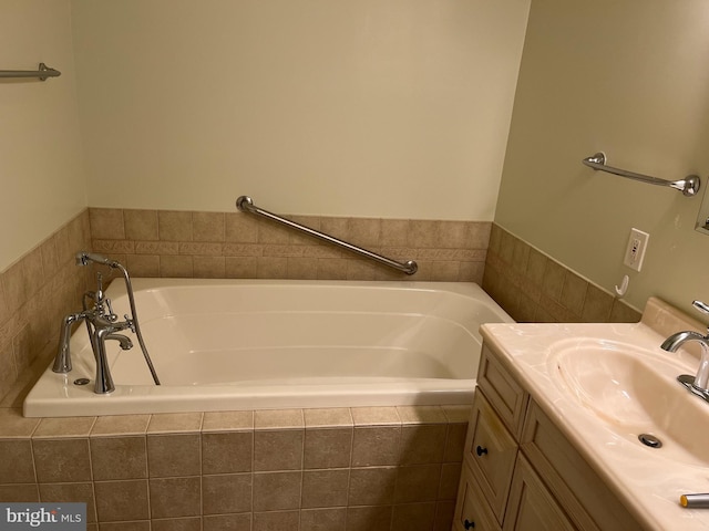 bathroom with tiled bath and vanity