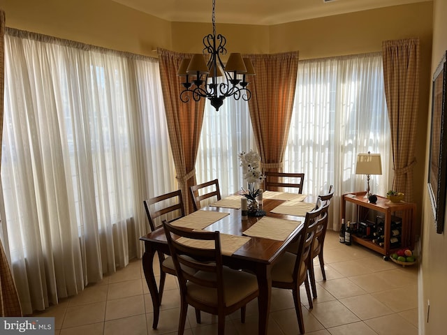 tiled dining room with a healthy amount of sunlight and a chandelier