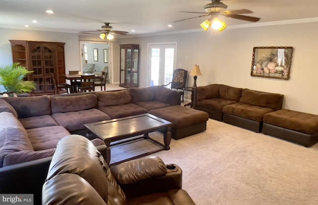 carpeted living room with ceiling fan and ornamental molding