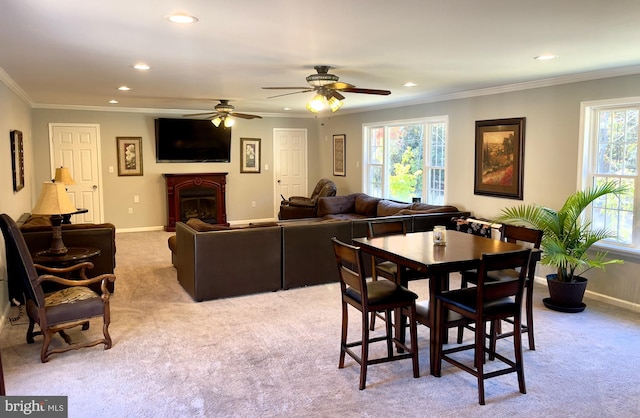 carpeted dining space featuring ornamental molding and ceiling fan