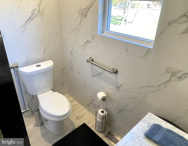 bathroom featuring tile walls and toilet