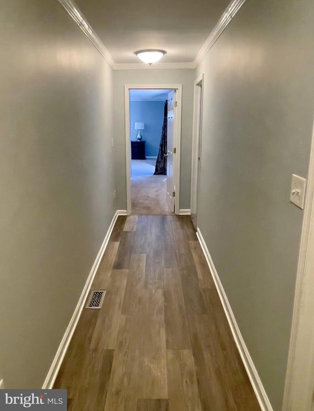 hallway featuring ornamental molding and hardwood / wood-style flooring