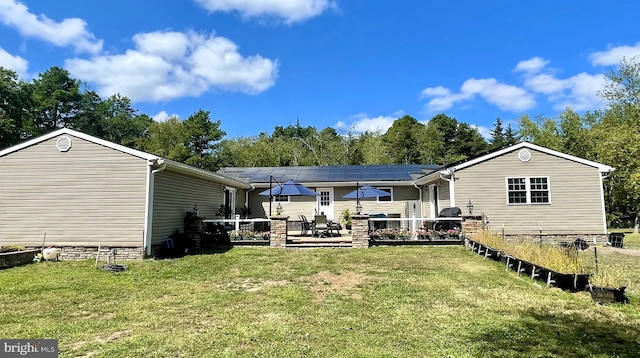 rear view of property featuring a deck and a lawn