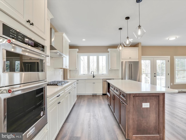 kitchen featuring white cabinetry, french doors, hanging light fixtures, a kitchen island, and appliances with stainless steel finishes