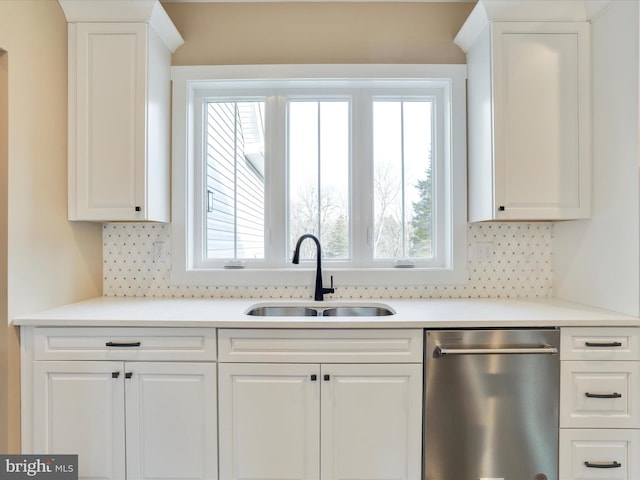 kitchen featuring dishwasher, backsplash, white cabinets, and sink