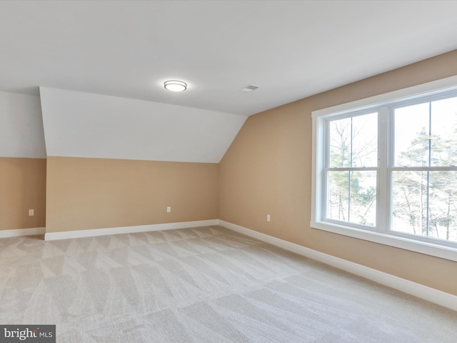 bonus room featuring light colored carpet and vaulted ceiling