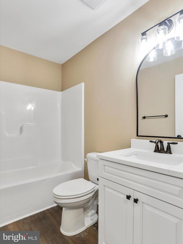 full bathroom with vanity, hardwood / wood-style flooring, toilet, and shower / washtub combination