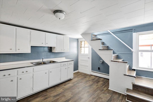 kitchen featuring a baseboard heating unit, sink, dark hardwood / wood-style floors, and white cabinets