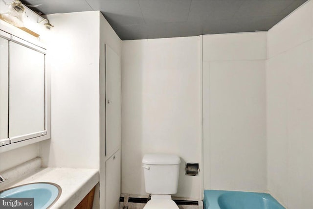 bathroom with toilet, a tub, vanity, and a baseboard heating unit