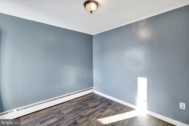 unfurnished room with a baseboard heating unit and dark wood-type flooring