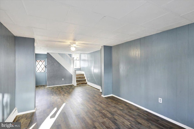 unfurnished room with a baseboard heating unit, ceiling fan, and dark hardwood / wood-style flooring