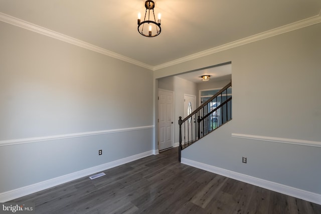 empty room featuring dark wood-type flooring and crown molding