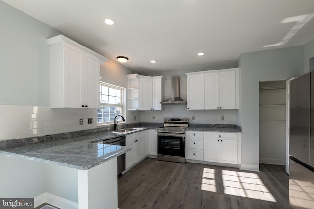 kitchen featuring appliances with stainless steel finishes, kitchen peninsula, white cabinetry, wall chimney exhaust hood, and dark wood-type flooring