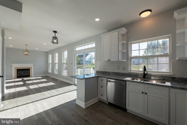 kitchen featuring dishwasher, white cabinetry, hanging light fixtures, and backsplash