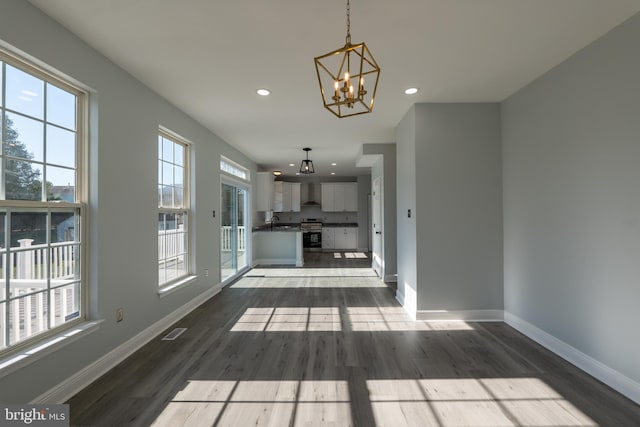 unfurnished living room featuring sink, hardwood / wood-style floors, and a chandelier