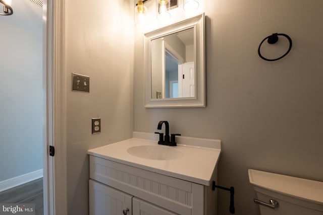 bathroom featuring vanity, hardwood / wood-style flooring, and toilet